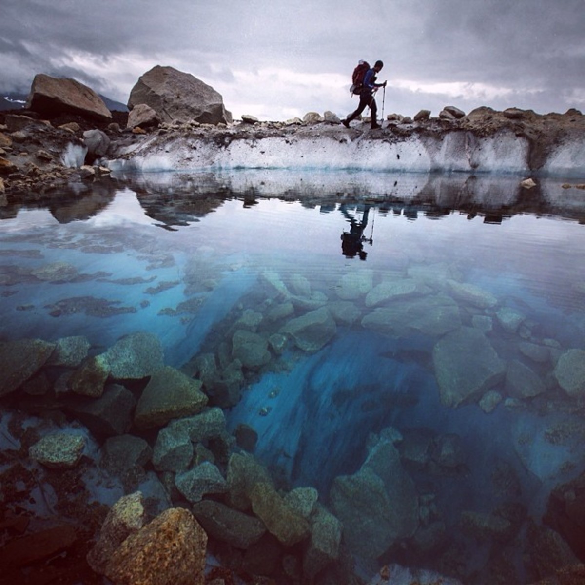 A climber Huey traveled with trudges along on the lower half of Ruth Glacier where there are no snow bridges and they can walk freely among deep blue pools. Photo by Aaron Huey from Facebook and Instagram