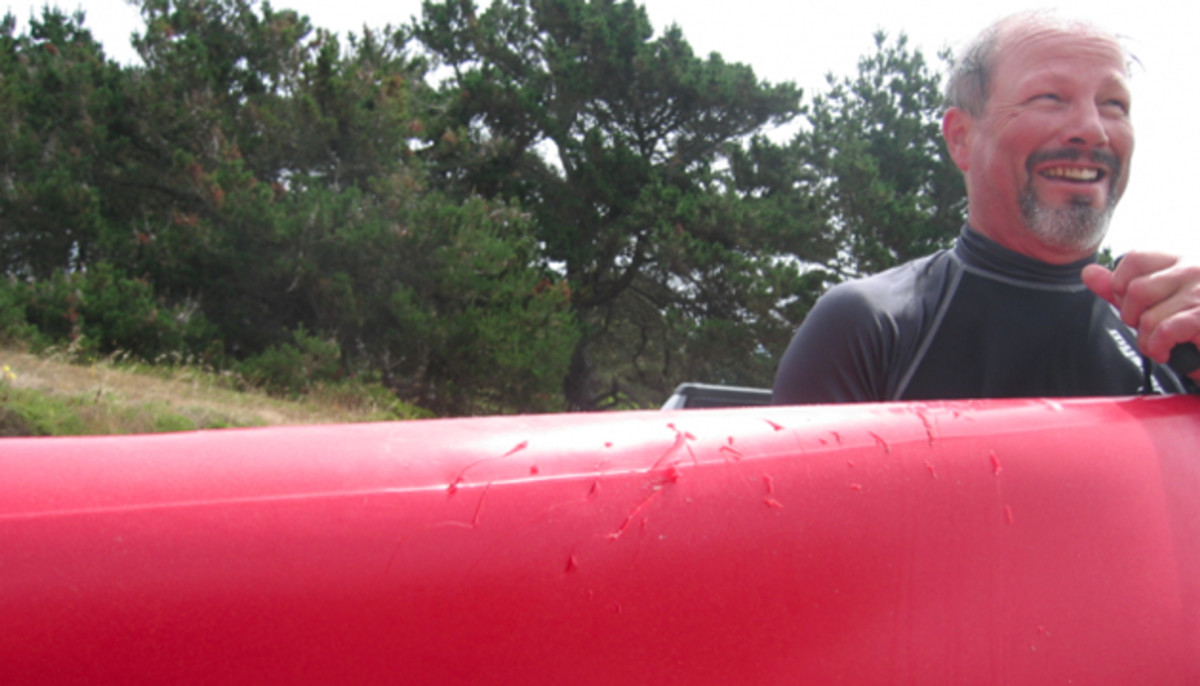Seeing red: Doug Prather's colorful Hobie Adventure sports several holes and cracks after a great white shark attack in 2007. Photo by Doug Mar.