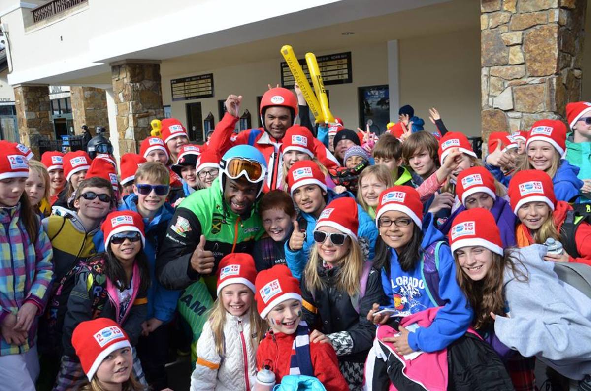 Jean-Pierre Roy and Michael Williams are surrounded by kids from a local school at the World Ski Championships in Vail. Photo from the Haitian Ski Federation Facebook page