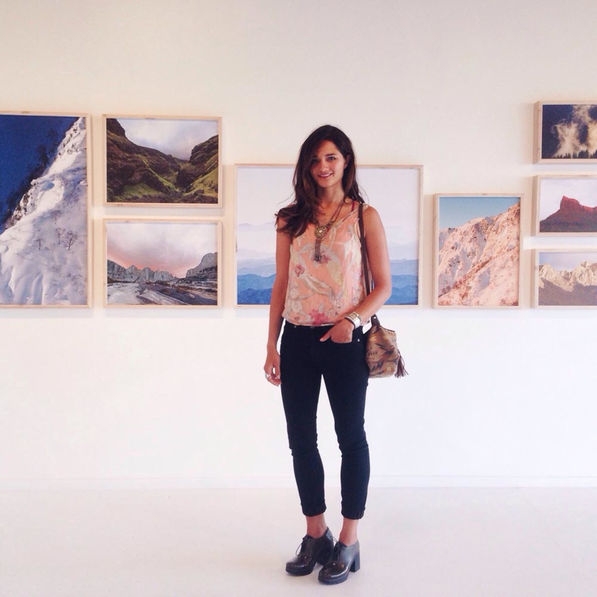 Meg Haywood-Sullivan poses in front of a gallery of her photography; Photo courtesy of Haywood-Sullivan