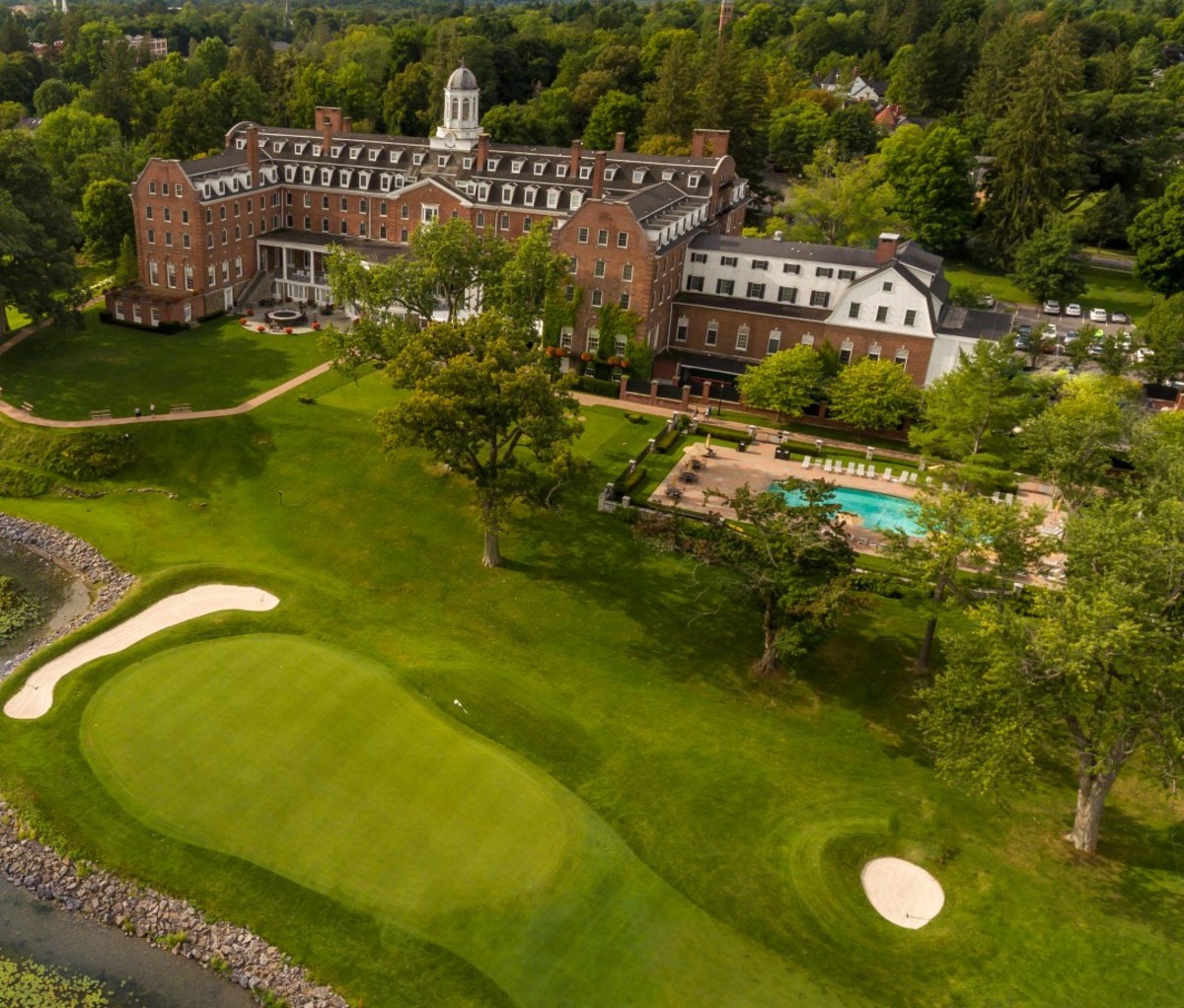 Aerial view of brick hotel with pool and golf course