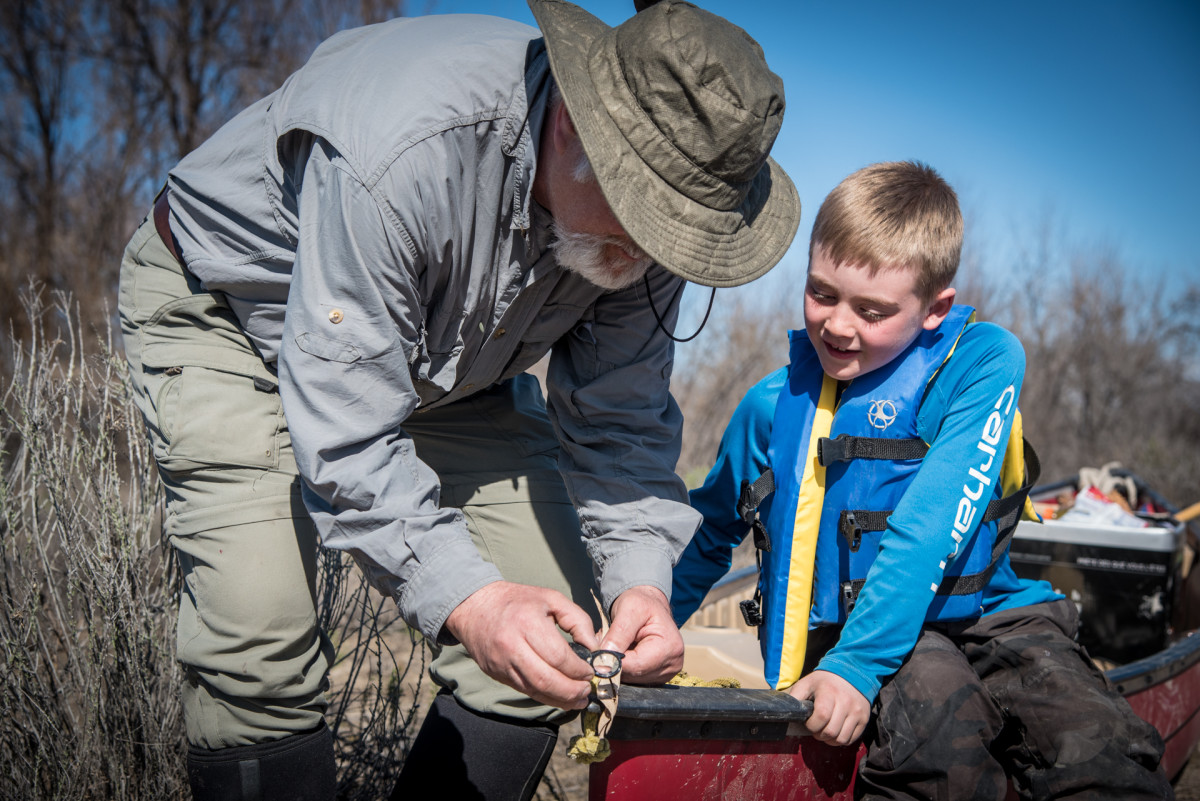 Alan teaching Dylan the art of woodburning with a magnifying glass.