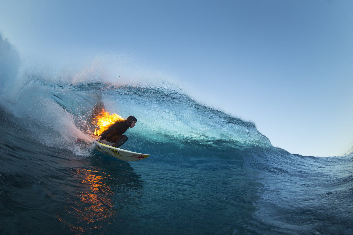 Jamie O'Brien surfs Teahupo'o while lit on fire. Photo: Red Bull Photo Pool