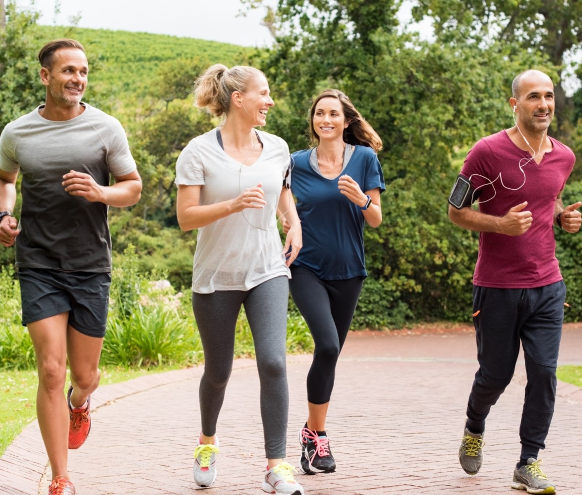 Group of men and women running outside. running benefits