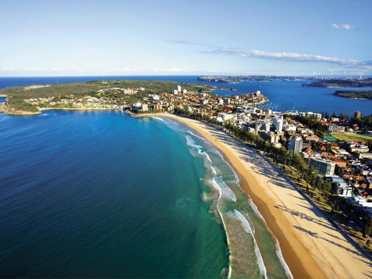 Sydney's Manly beach with the harbor and city in background. Photo by Visit Sydney