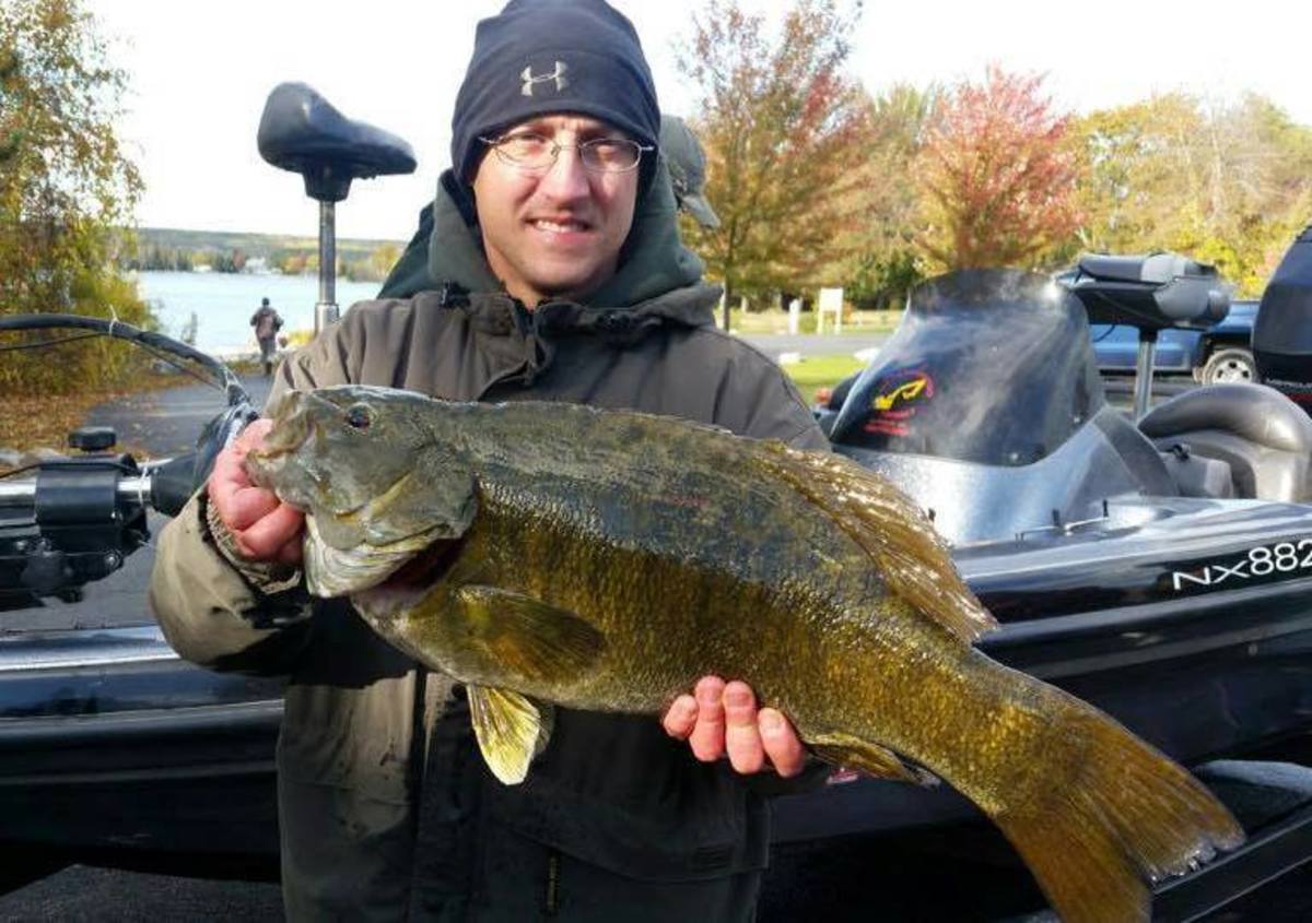 Greg Gasiciel holds up his Michigan state-record smallmouth bass caught at Hubbard Lake.