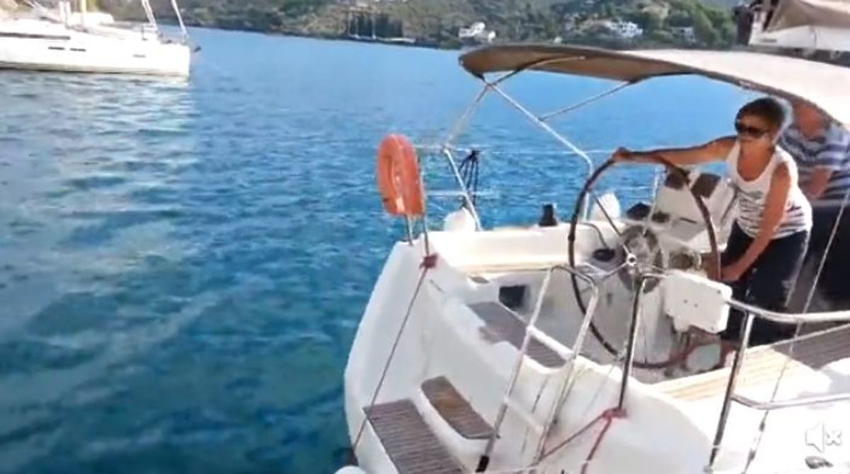 A woman seen in this screen grab is attempting to dock a sailboat but instead produces a blooper.