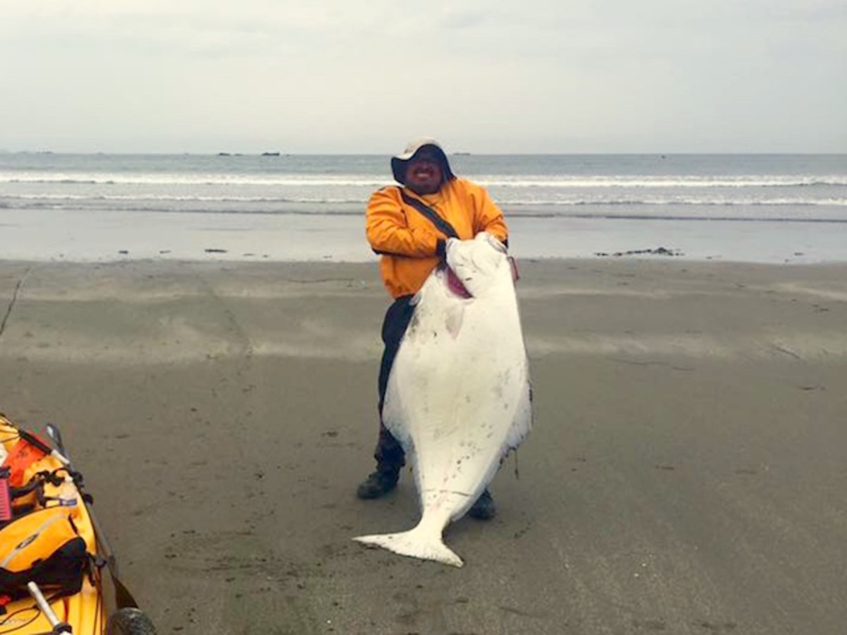 Leo Vergara hefts his monster kayak record halibut after a wild battle 5 miles offshore. Photo Rich Fargo