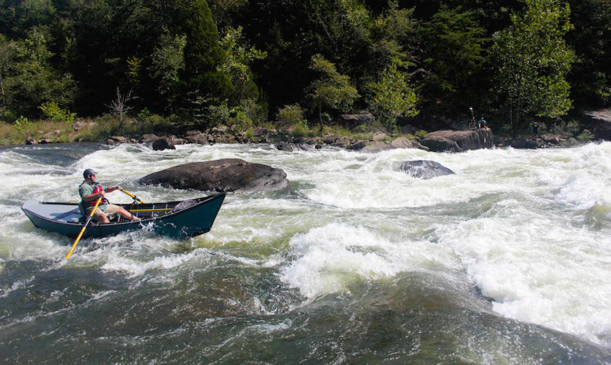 Curtis Warner pilots his hand-made drift boat through Pillow Rock Rapid on the Upper Gauley. Photo by Ted Varney.