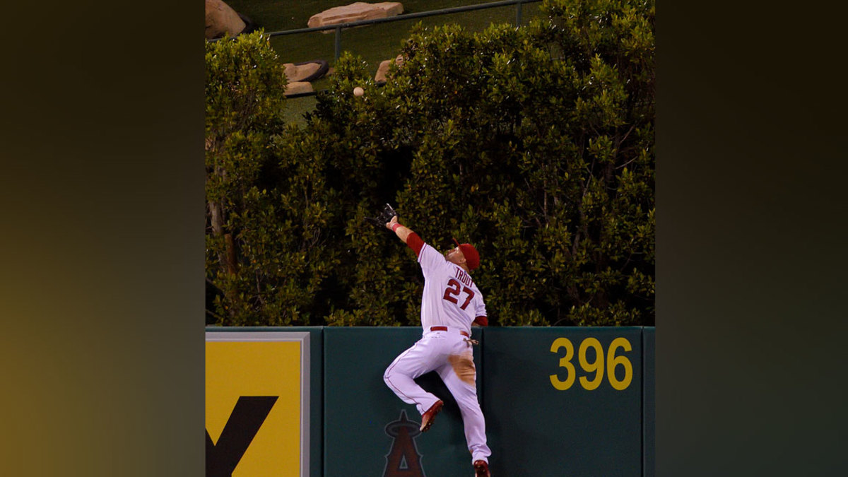 Mike Trout #27 of the Los Angeles Angels of Anaheim makes a catch high over the wall to rob Jesus Montero of the Seattle Mariners of what would have been a three-run home run during the fourth inning of the game against the Seattle Mariners at Angel Stadium of Anaheim on September 26, 2015 in Anaheim, California. (Photo by Matt Brown/Angels Baseball LP/Getty Images)