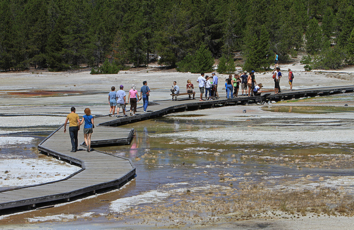 Tourists walk along the boardwalk in Norris Geyser Basin.