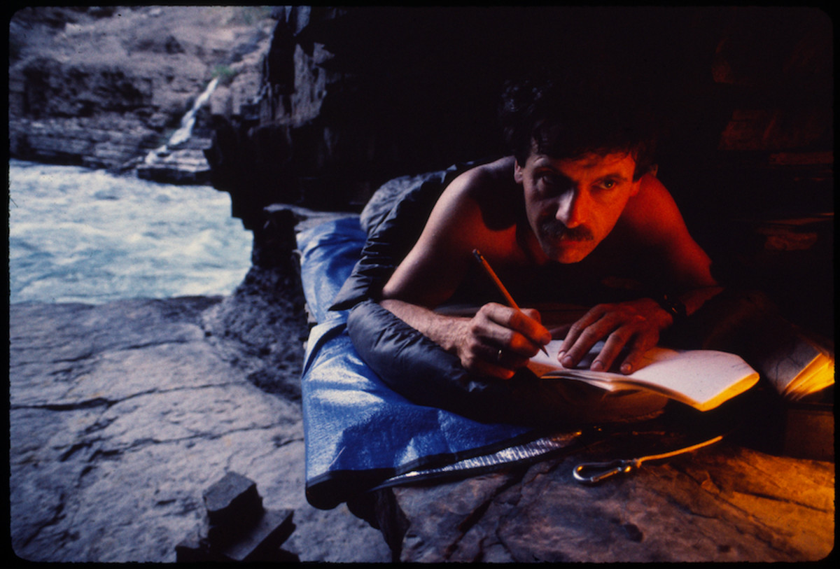 Piotr Chmielinski writes in his diary in a cave at the bottom of Colca Canyon. Photo by Zbigniew Bzdak