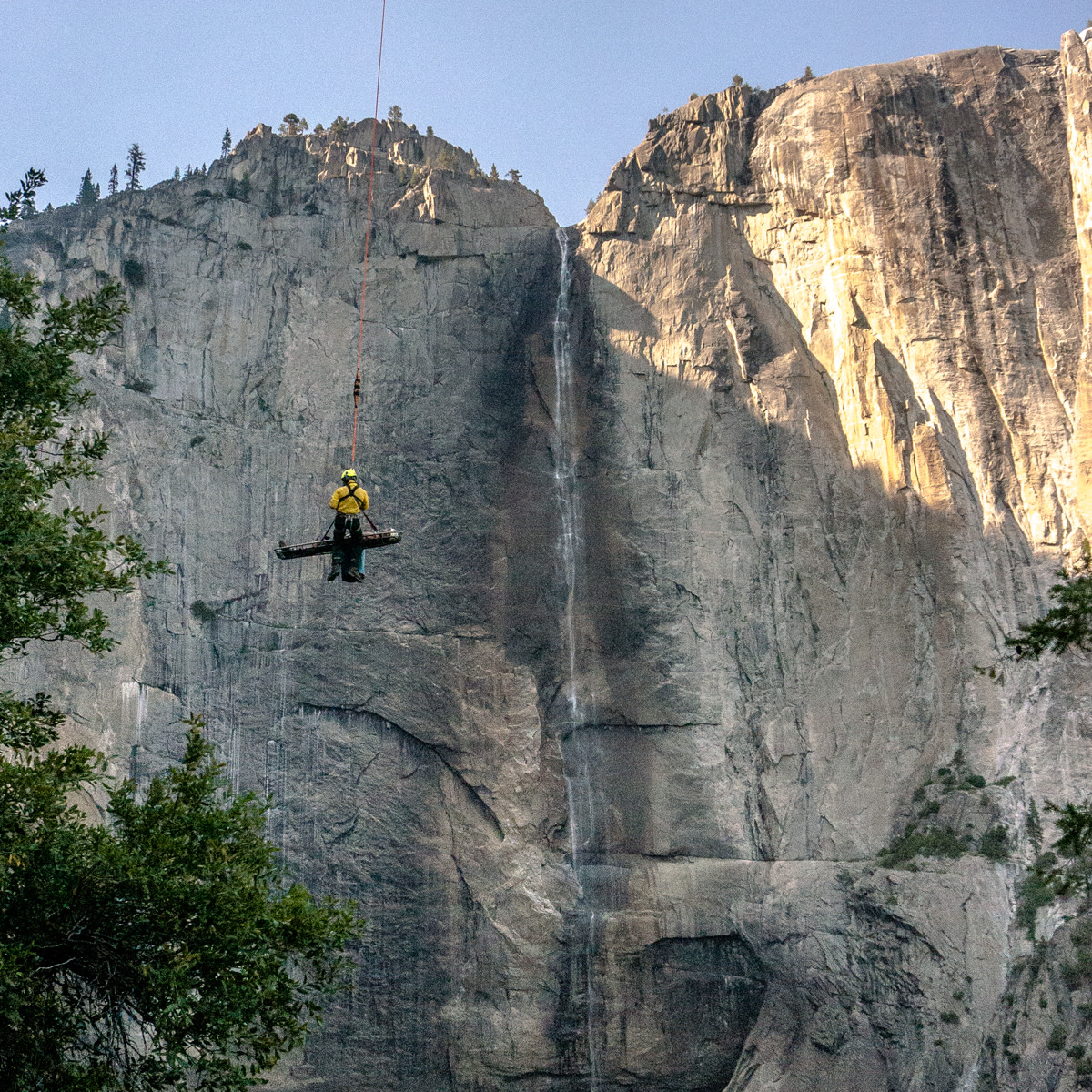 Park Medic and Park Service Ranger Tom Heally takes the views in as Yosemite Fire 551 short hauls him and his patient away from the Yosemite Falls trail. Photo courtesy Josh Huckaby
