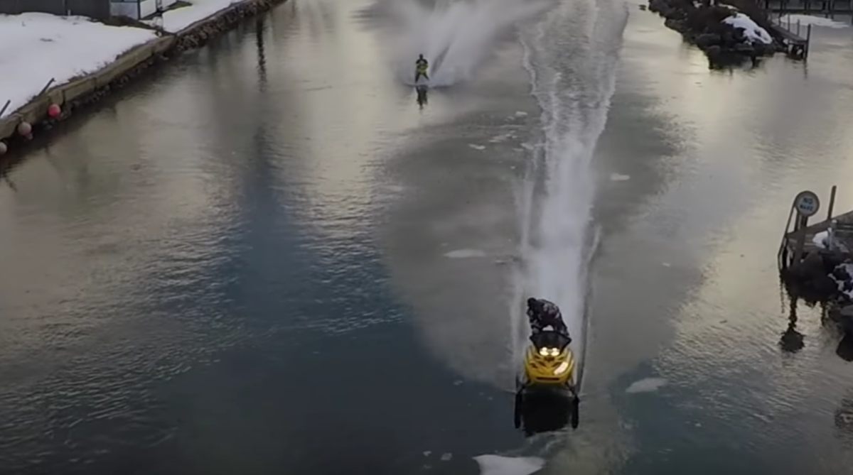 Snowmobile skimming lake winnipesaukee