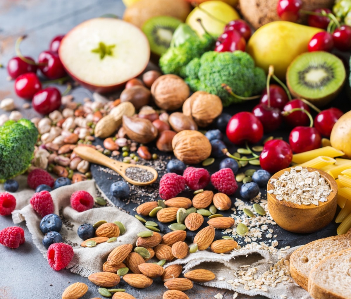 Fruits, nuts, vegetables and pasta spilling on a table. fitness tips