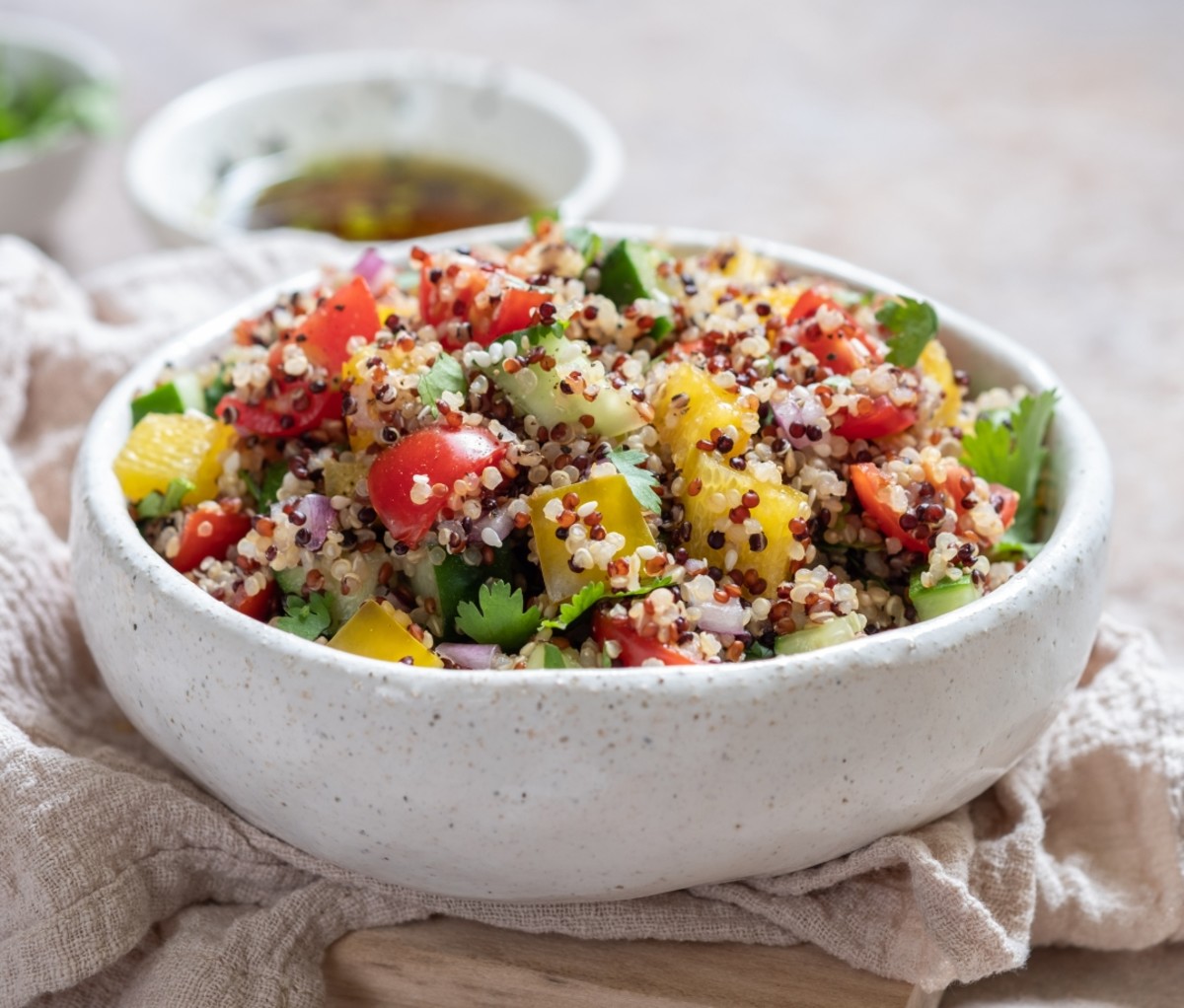 Quinoa salad in a white bowl on a table. fitness tips