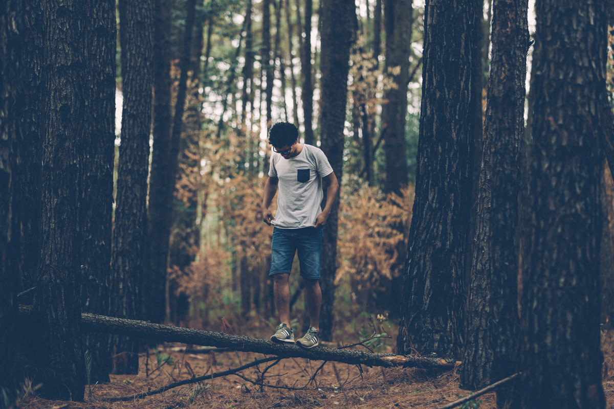 man balancing on log