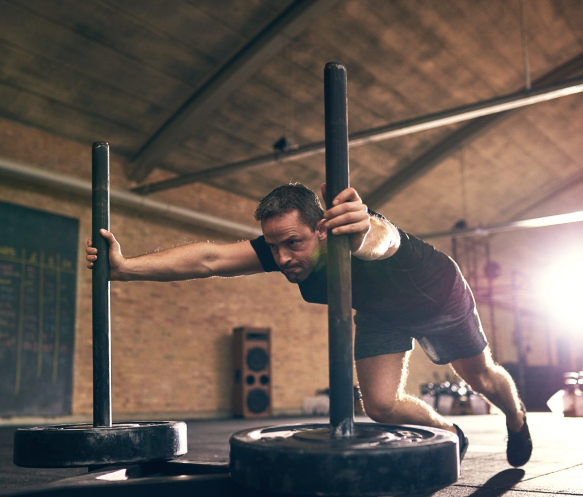 Man pushing a weight sled in the gym.