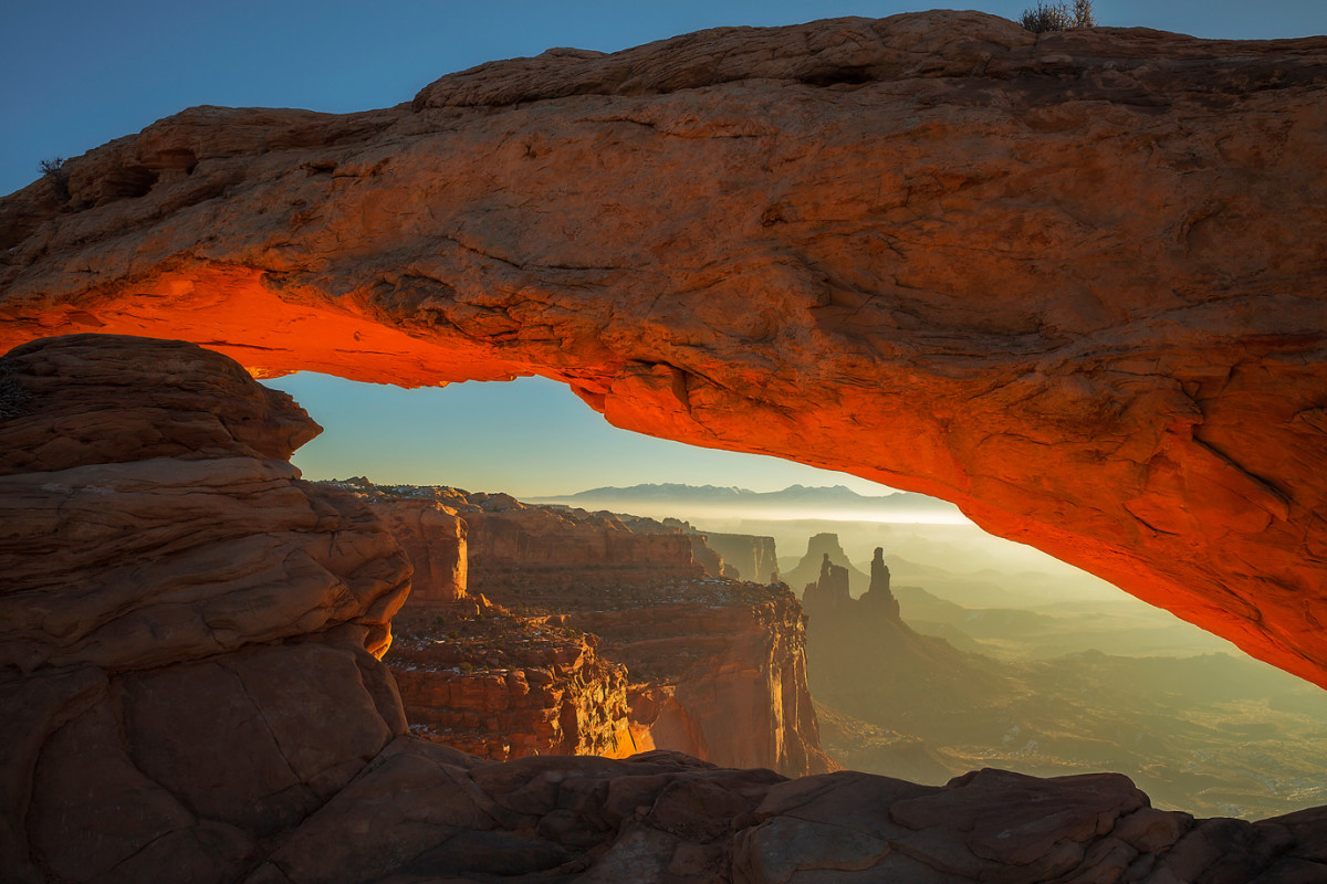 A winter sunrise illuminates the underside of Mesa Arch in Canyonlands National Parks, Utah.