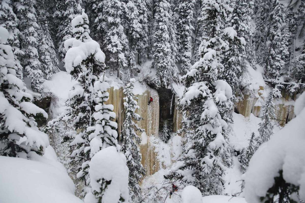 A top down view of a man rappelling on a frozen waterfall in British Columbia.