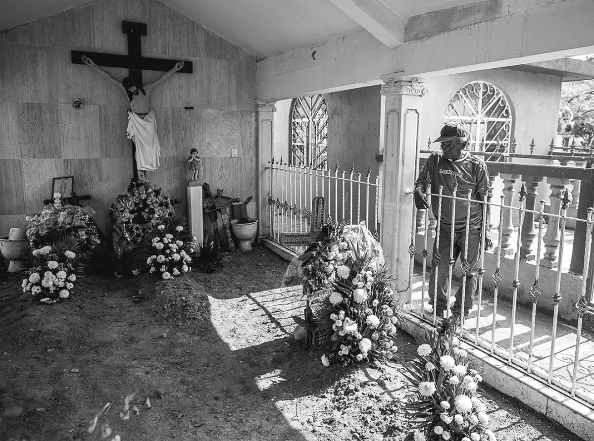 Contreras stops by the tomb of Octavio Colorado Mora, a mechanic whose body he found at a mass-burial site.
