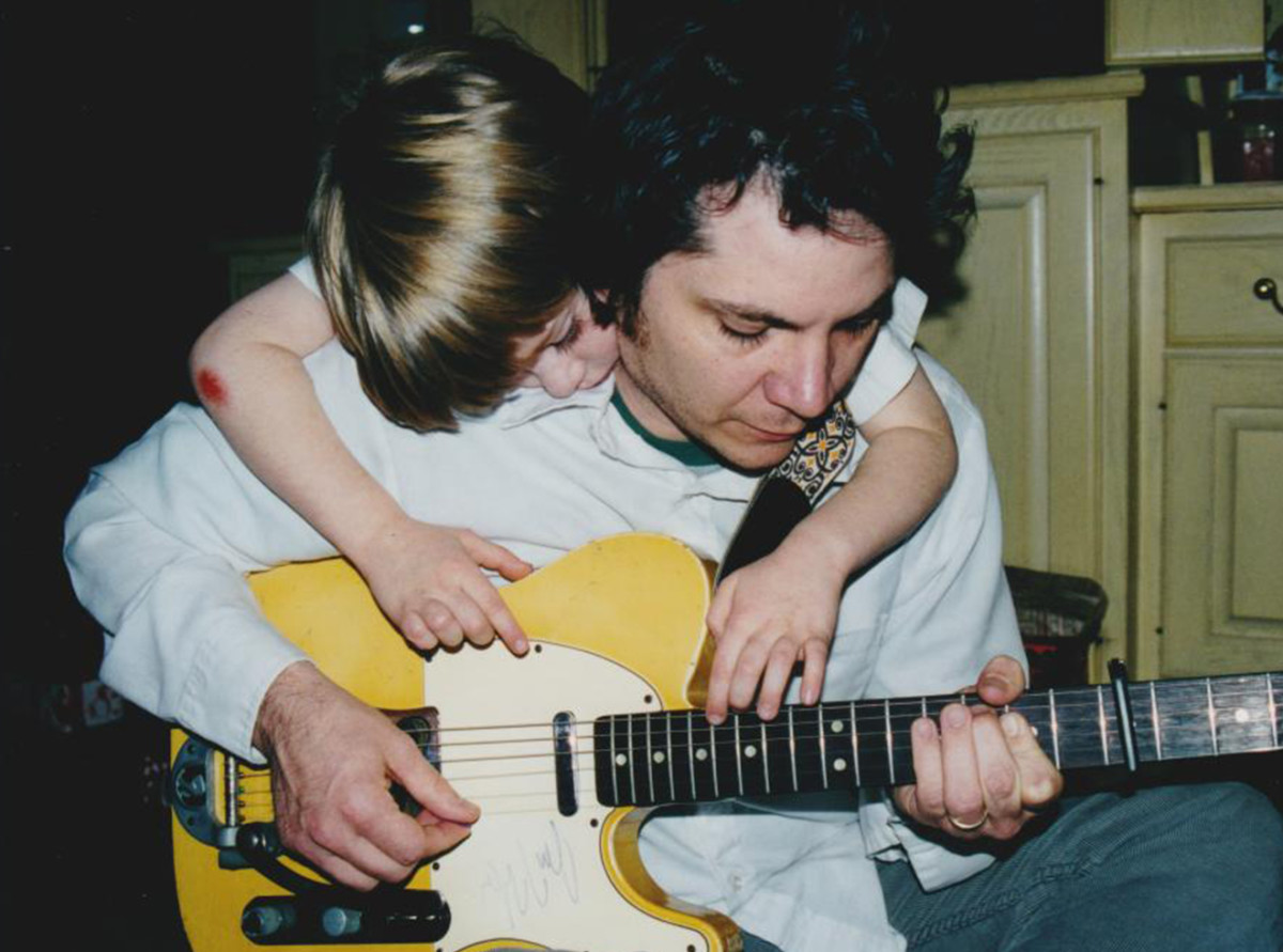 Tweedy picks a Telecaster as his oldest son, Spencer—now 23 and a drummer who recorded the 2014 album Sukierae with his dad—watches.