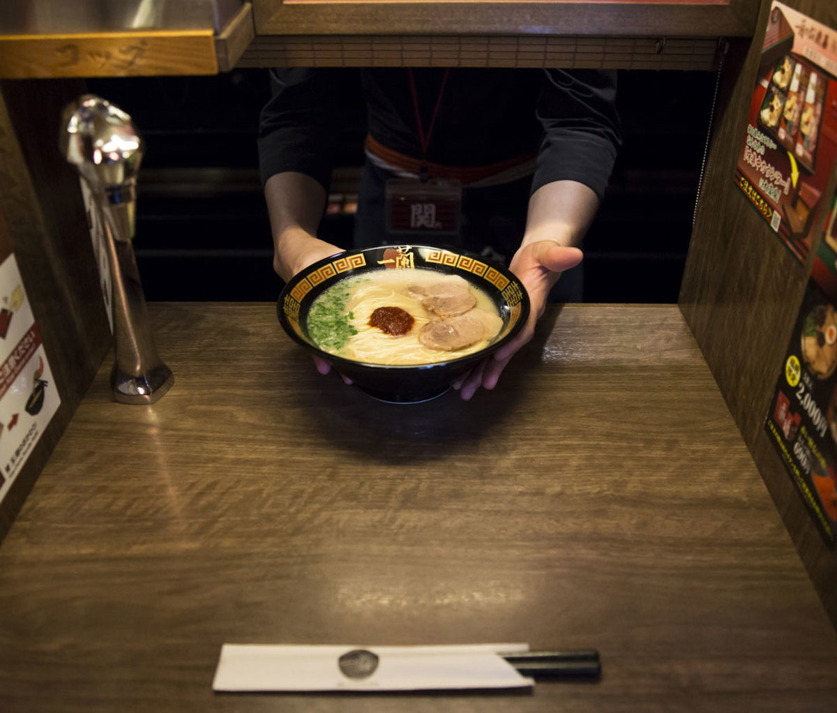 An employee serves a bowl of tonkotsu ramen at Ichiran restaurant in Fukuoka
