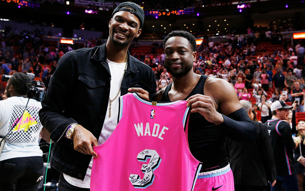 Dwyane Wade #3 of the Miami Heat greets former Miami Heat teammate Chris Bosh with a jersey after the game against the Cleveland Cavaliers at American Airlines Arena on December 28, 2018 in Miami, Florida