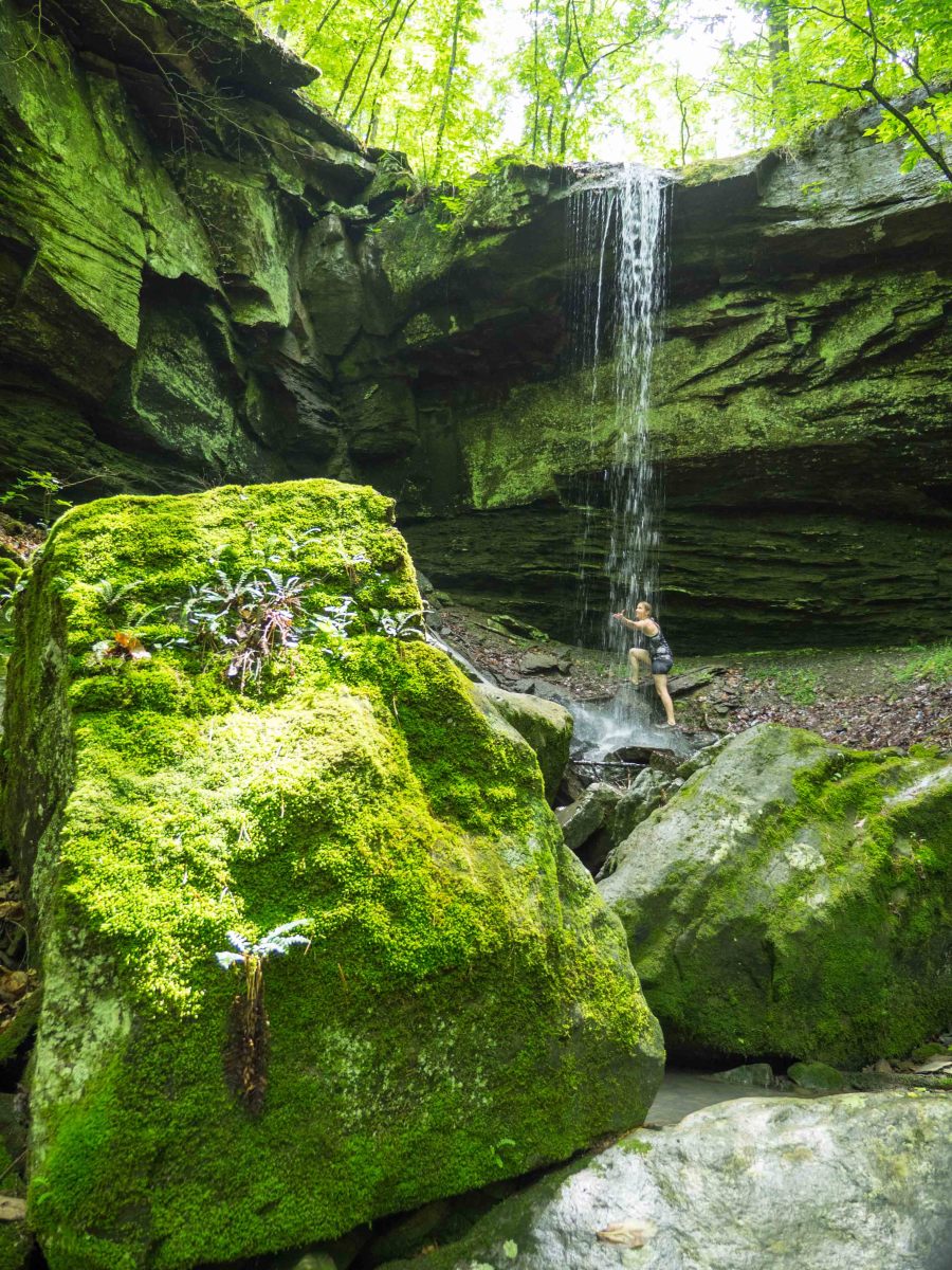 A hiker reachers for a waterfall