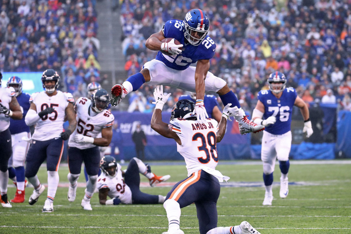 EAST RUTHERFORD, NEW JERSEY - DECEMBER 02: Saquon Barkley #26 of the New York Giants leaps over Adrian Amos #38 of the Chicago Bears for extra yardage during the third quarter at MetLife Stadium on December 02, 2018 in East Rutherford, New Jersey. (Photo by Al Bello/Getty Images)