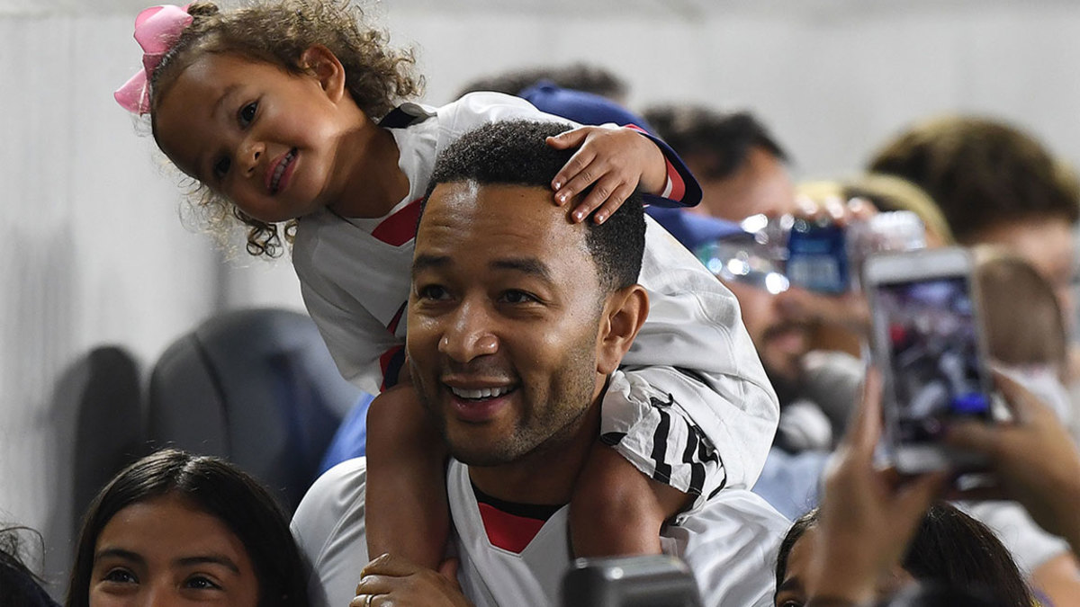 US singer John Legend and daughter Luna watch the International Women's friendly football match between the US and Belgium at the Banc of California Stadium in Los Angeles on April 7, 2019. (Photo by Mark RALSTON / AFP) (Photo credit should read MARK RALSTON/AFP/Getty Images)