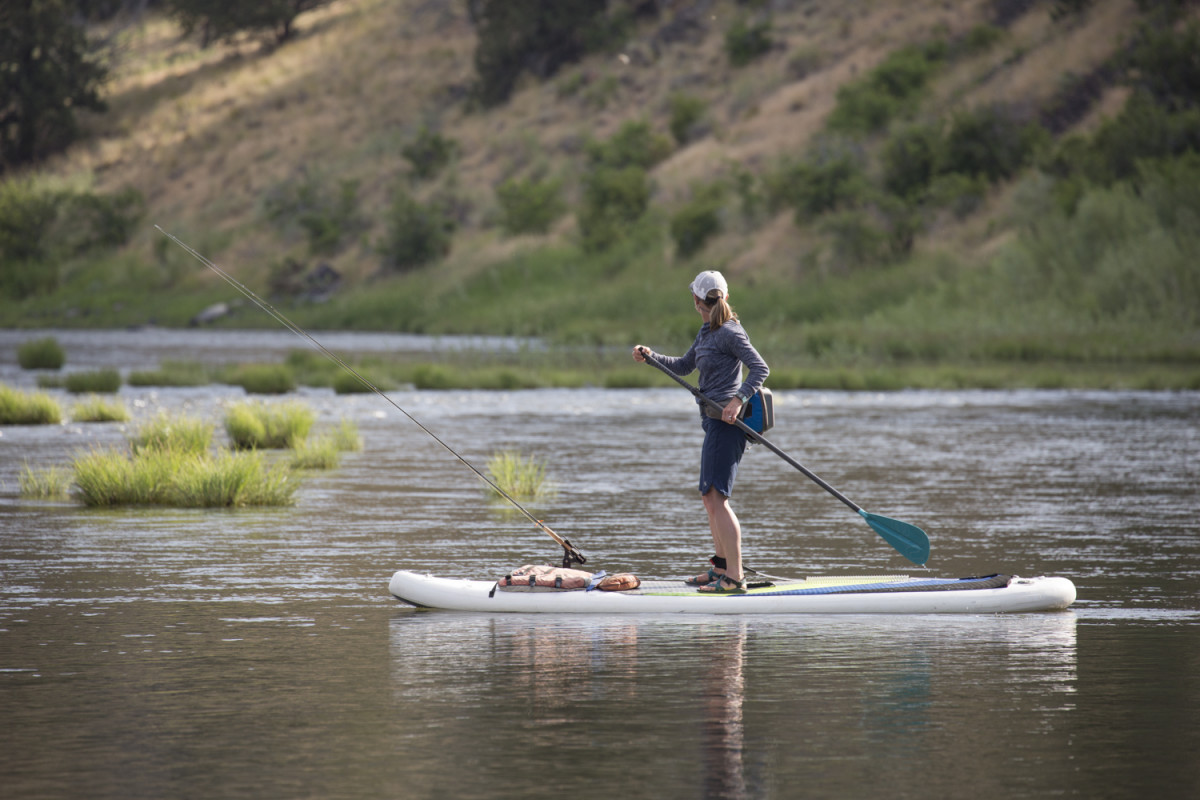 Woman on stand-up paddleboard navigates the John Day River in Oregon.