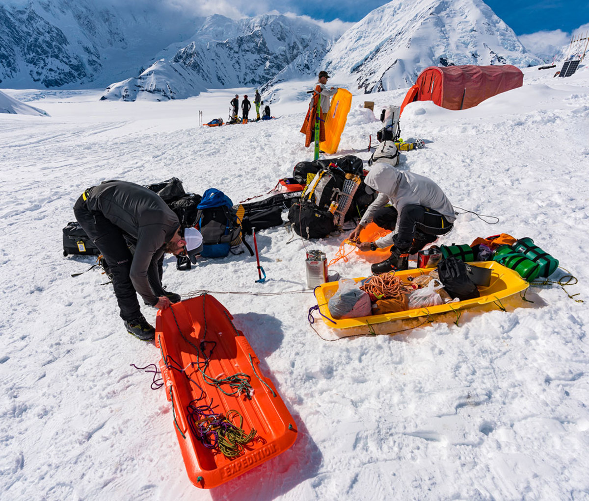 Mike Chambers, Jason Antin, and Will Seeber packing sleds with gear