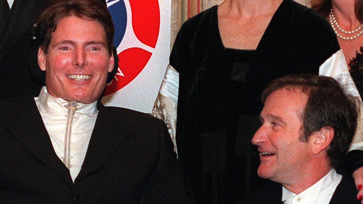 REEVE WILLIAMS Actor Robin Williams, right, looks up at his friend and colleague Christopher Reeve as they pose for photographers at an American Paralysis Association dinner in New York . Reeve, himself a spinal injury victim, is the current chairman of the board of the association