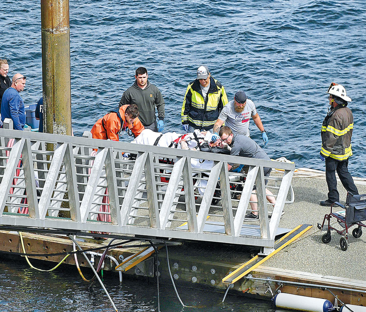 Emergency workers transport an injured person after the midair crash in May.