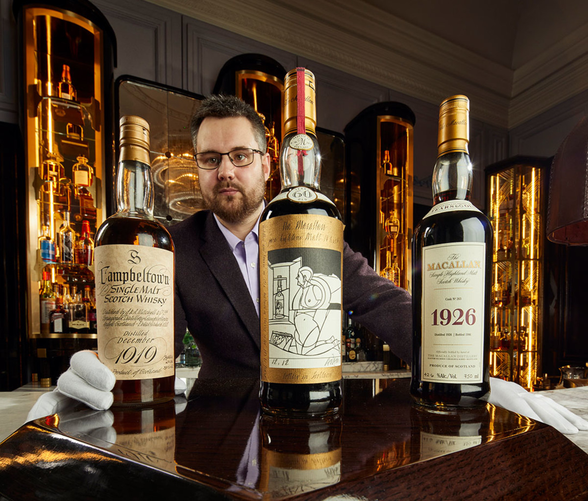 Whisky Auctioneer founder Iain McClune with bottles of Springbank and Macallan