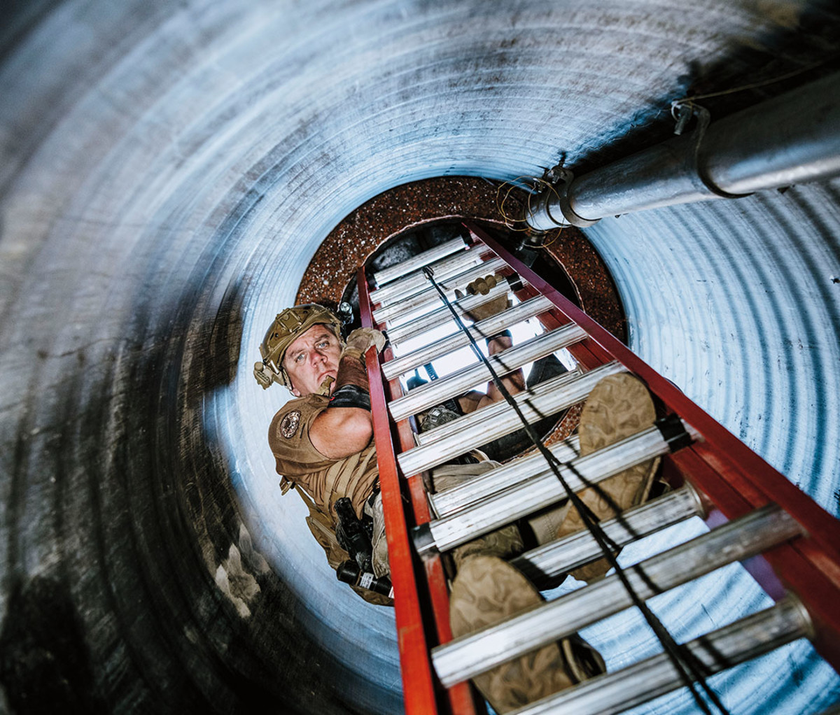 LeNoir descends a ladder through a vertical shaft retrofitted for training purposes.