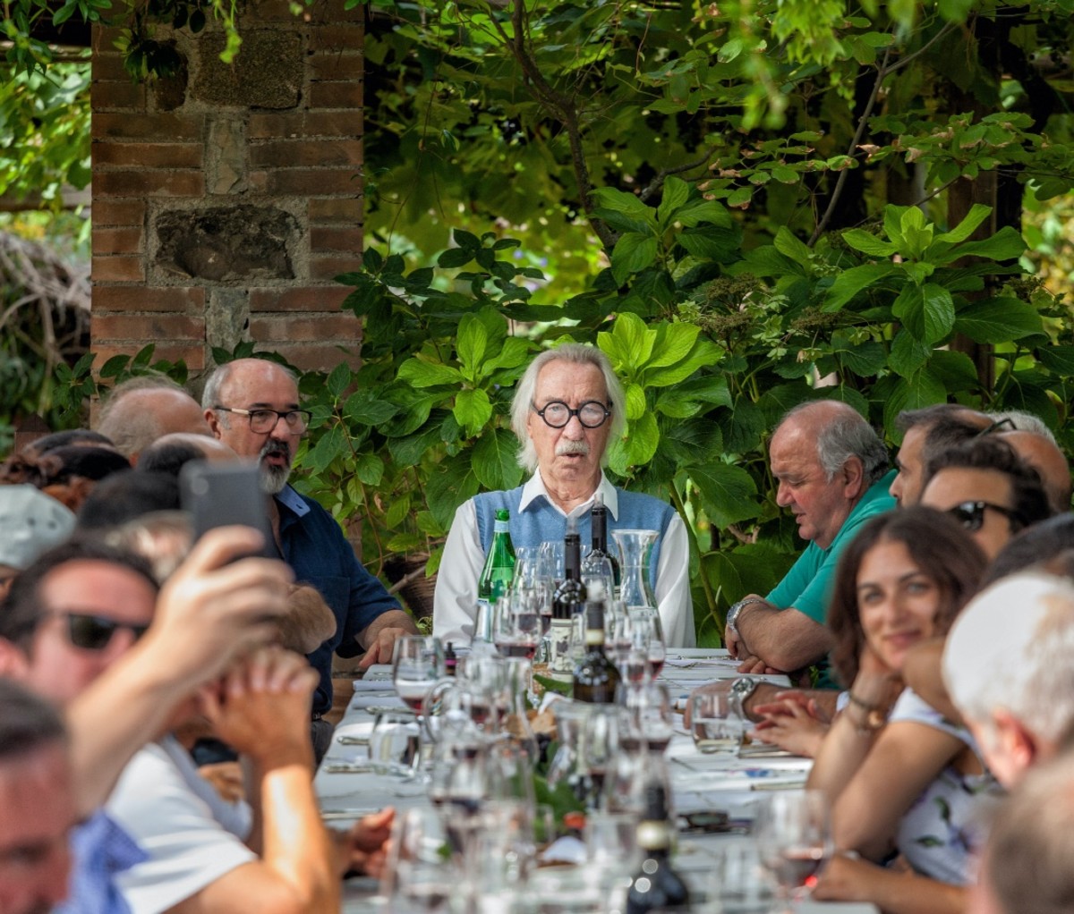 Group of traditional folk singers performing at the end of the table at lunch at Castello di Argiano