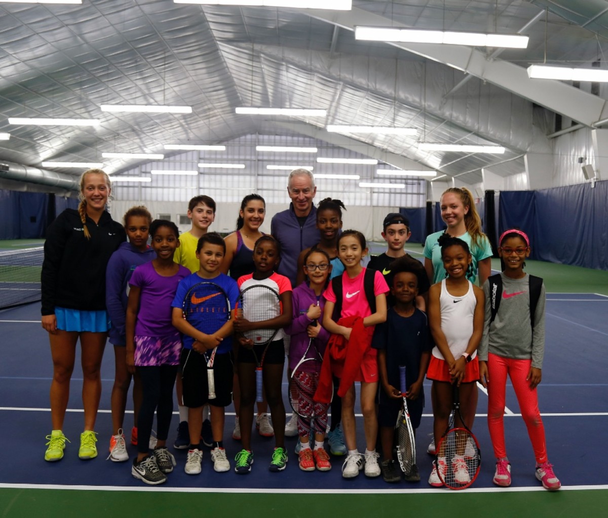 John McEnroe and youth tennis players at John McEnroe Tennis Academy