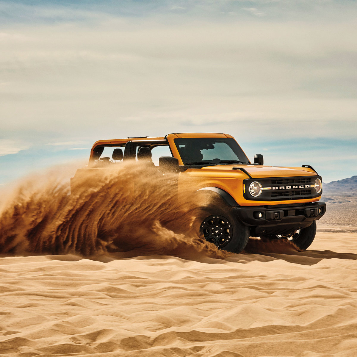 Ford Bronco tearing through sand in desert