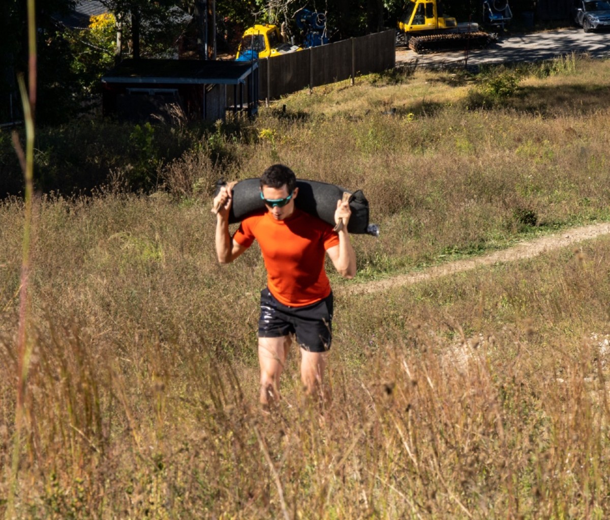 OCR athlete Ryan Kempson doing weighted hill run with sandbag on shoulders
