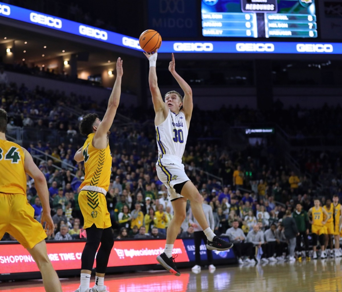 SDSU March Madness Upsets 2022 South Dakota State guard Charlie Easley (30) shoots over a North Dakota State defender.