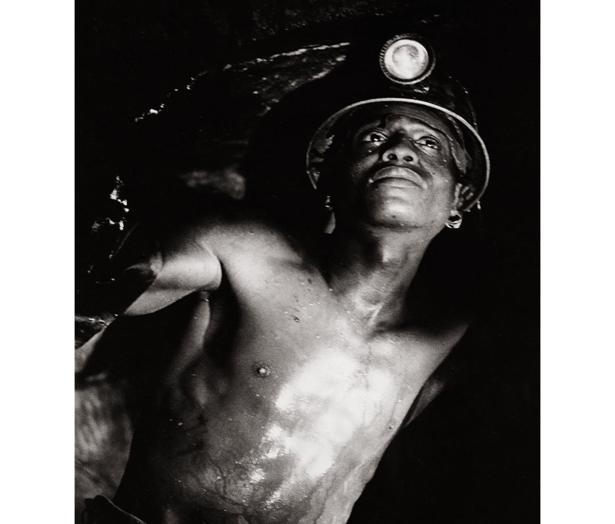 Young South African boy wearing miner's hard hat searching for diamonds