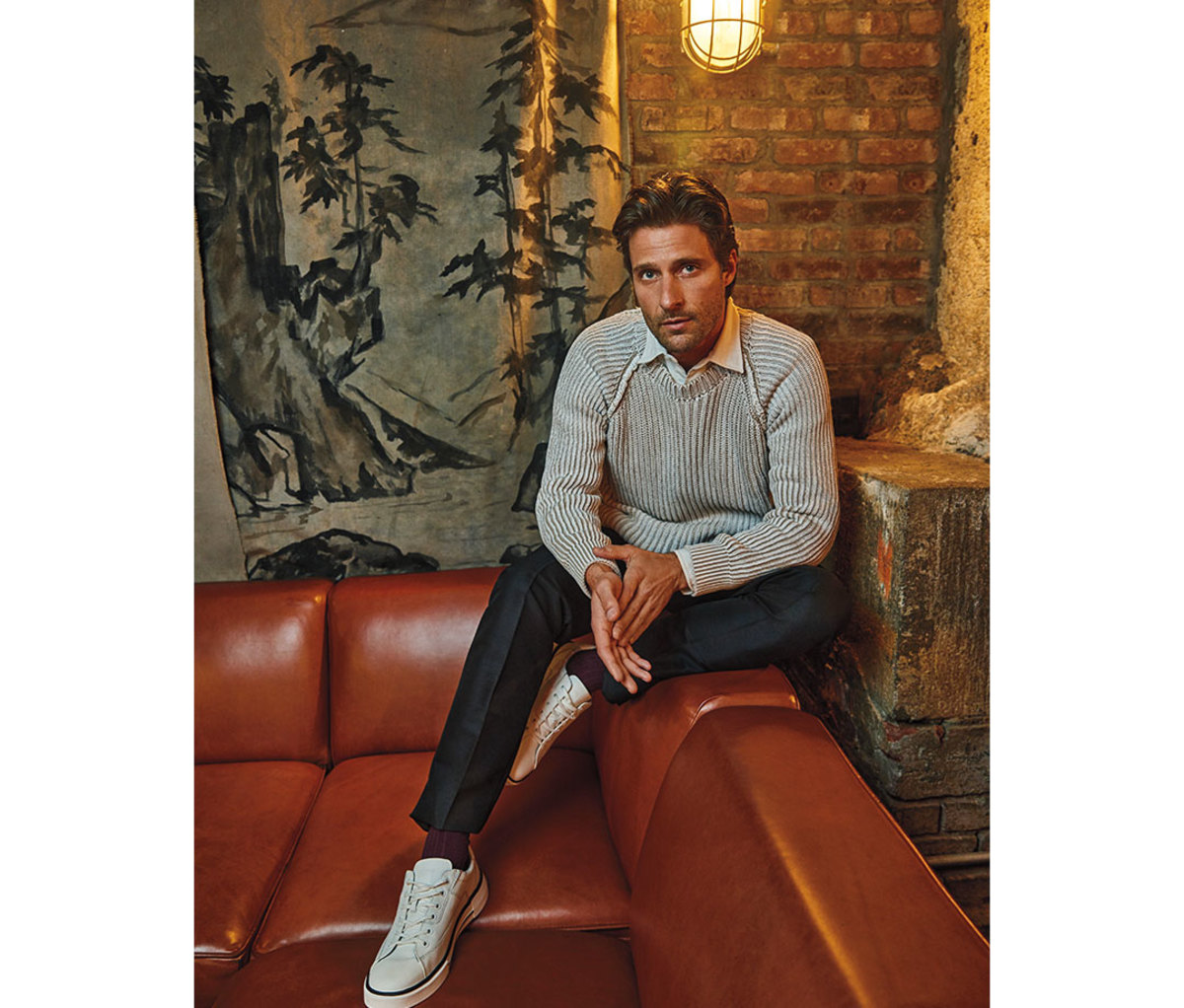 Caucasian man in his 30s sitting on leather couch