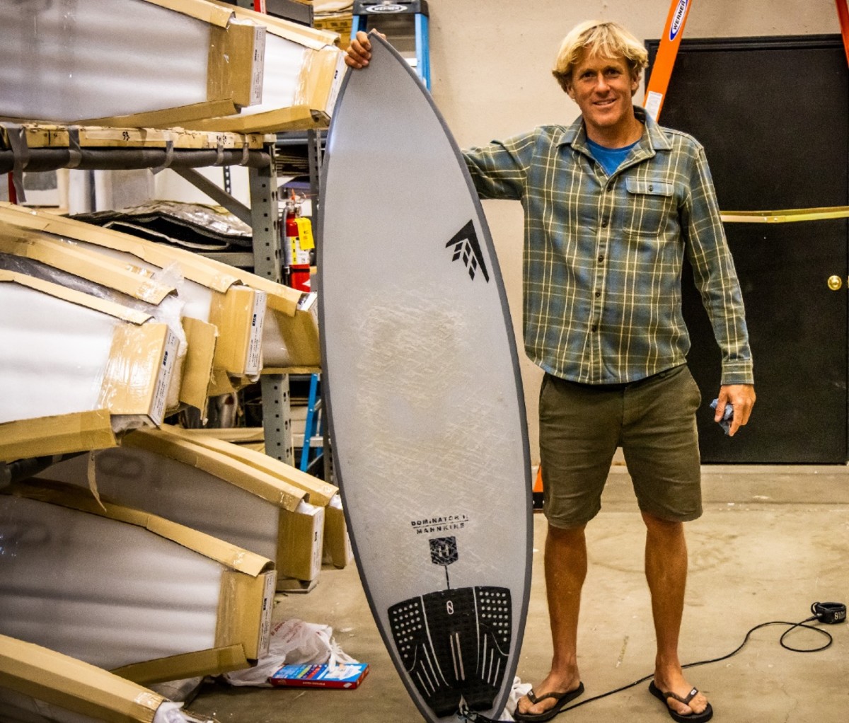 Man holding surfboard in surf shop