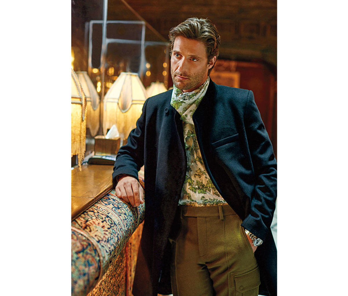 Caucasian man in his 30s leaning against table