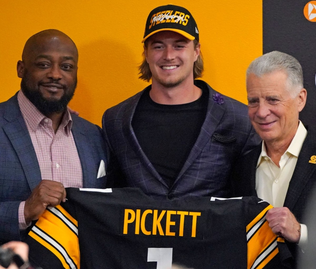 Quarterback Kenny Pickett, center, the Pittsburgh Steelers first-round draft pick, poses for a photo with head coach Mike Tomlin, left, and President/owner Art Rooney II against a yellow background. NFL Draft 2022