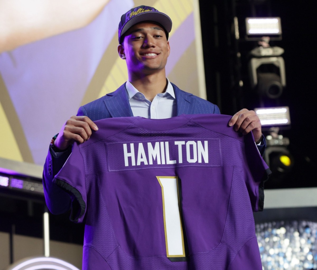 Kyle Hamilton holding up his Baltimore Ravens jersey showing his name and number. NFL Draft 2022