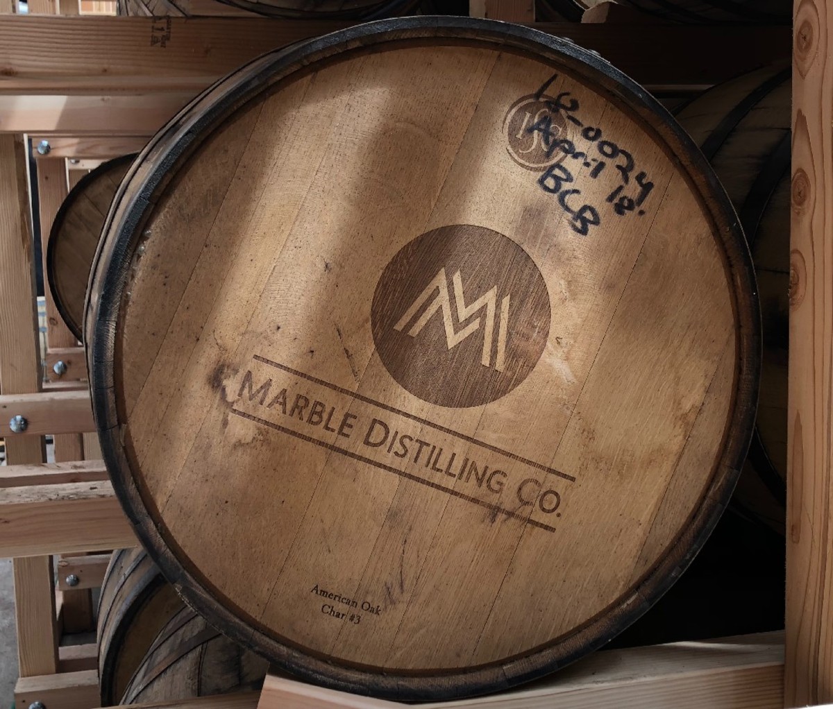 Een bovenaanzicht van een vat met het Marble Distilling Co.-logo erop.