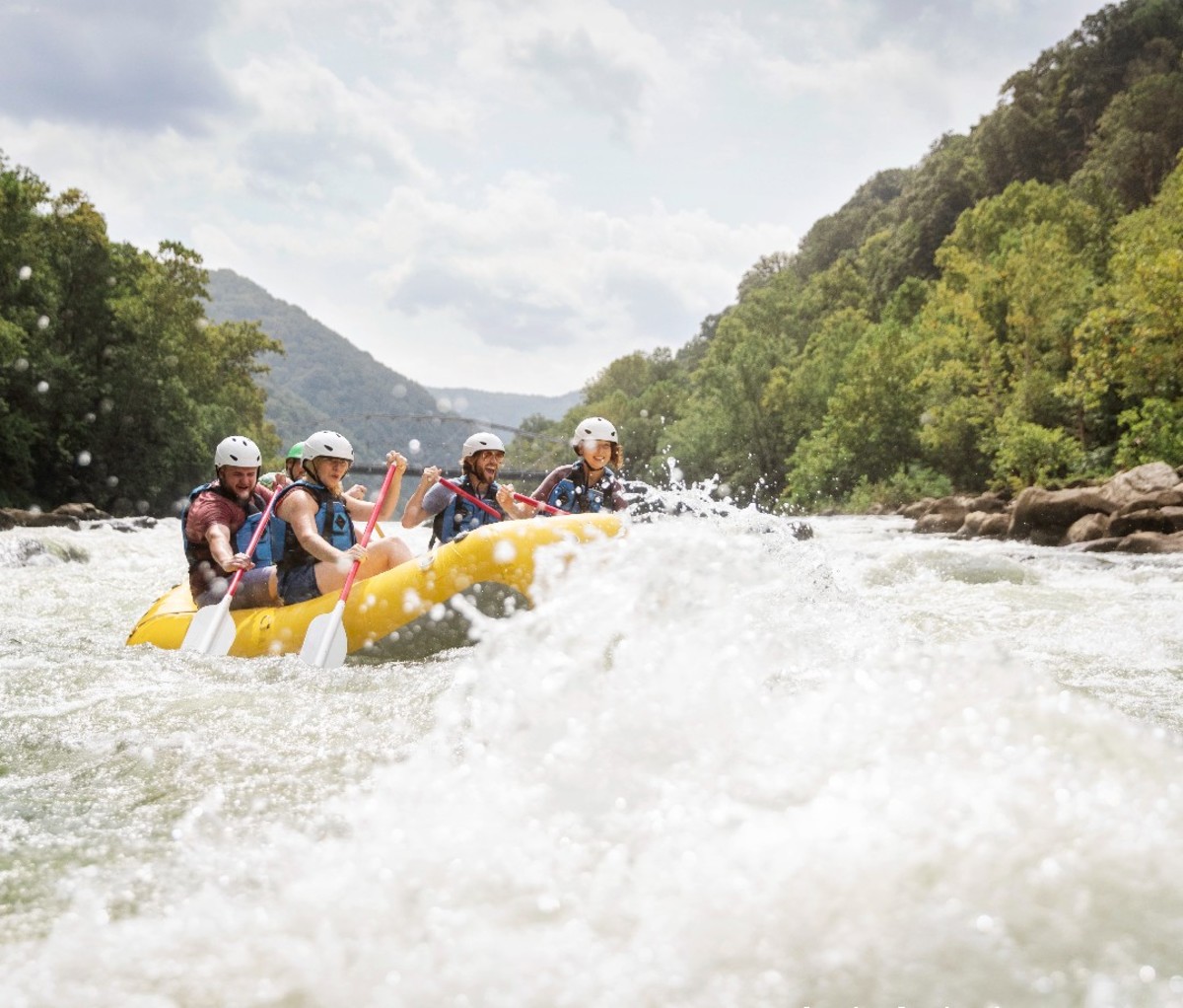 A raft with paddlers goes through whitewater in West Virginia's New River Gorge.